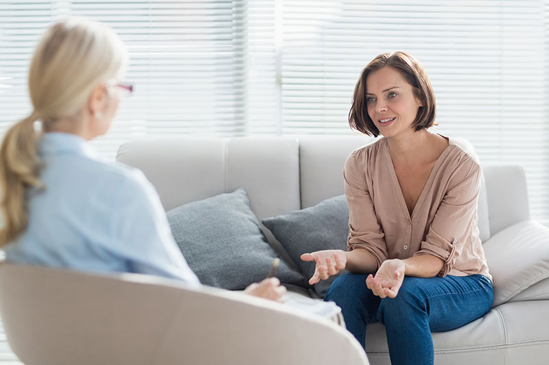 dual-diagnosis-rehab Therapist talking to client on couch